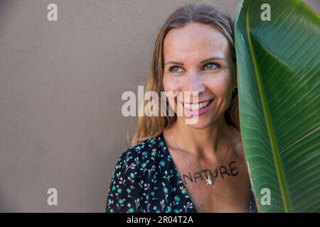 Portrait d'une activité environnementale avec une feuille et le mot nature écrit sur la poitrine Banque D'Images