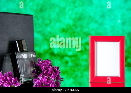 vue de face fragnance noire avec cadre d'image rose sur fond vert portrait cadeau parfum présent couleur parfum amour fleur mariage Banque D'Images