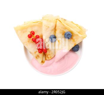 Crêpes délicieuses avec yaourt naturel, bleuets et raisins rouges sur fond blanc, vue du dessus Banque D'Images