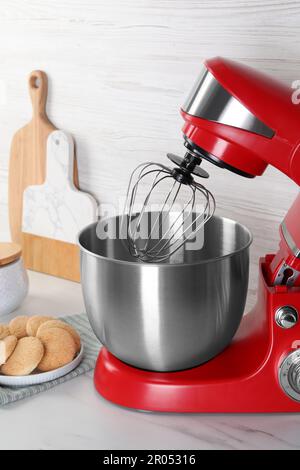 Batteur rouge moderne et biscuits sur table en marbre blanc Banque D'Images