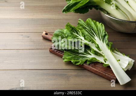 Feuilles de chou blanc vert frais avec gouttes d'eau sur table en bois, espace pour le texte Banque D'Images