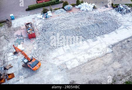 Schwerin, Allemagne. 04th mai 2023. Une pelle hydraulique se trouve devant les vestiges de la maison de réfugiés qui a brûlé en 19.10.2022 et qui a depuis été démolie. (Photo aérienne prise avec un drone) le 10.05.2023, le procès de l'homme prétendument responsable de l'incendie commencera au tribunal régional de Schwerin. Selon l'acte d'accusation, le pompier de 32 ans aurait mis le feu au toit de chaume de l'ancien hôtel, qui au moment du crime a été utilisé comme logement pour les réfugiés d'Ukraine. Credit: Jens Büttner/dpa/Alay Live News Banque D'Images