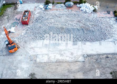 Schwerin, Allemagne. 04th mai 2023. Une pelle hydraulique se trouve devant les vestiges de la maison de réfugiés qui a brûlé en 19.10.2022 et qui a depuis été démolie. (Photo aérienne prise avec un drone) le 10.05.2023, le procès de l'homme prétendument responsable de l'incendie commencera au tribunal régional de Schwerin. Selon l'acte d'accusation, le pompier de 32 ans aurait mis le feu au toit de chaume de l'ancien hôtel, qui au moment du crime a été utilisé comme logement pour les réfugiés d'Ukraine. Credit: Jens Büttner/dpa/Alay Live News Banque D'Images