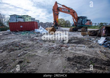 Schwerin, Allemagne. 04th mai 2023. Une pelle hydraulique se trouve devant les vestiges de la maison de réfugiés qui a brûlé en 19.10.2022 et qui a depuis été démolie. (Photo aérienne prise avec un drone) le 10.05.2023, le procès de l'homme prétendument responsable de l'incendie commencera au tribunal régional de Schwerin. Selon l'acte d'accusation, le pompier de 32 ans aurait mis le feu au toit de chaume de l'ancien hôtel, qui au moment du crime a été utilisé comme logement pour les réfugiés d'Ukraine. Credit: Jens Büttner/dpa/Alay Live News Banque D'Images