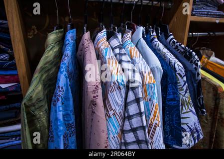 Variété colorée de tentures de chemises dans une salle d'exposition de vêtements. Mise au point rapprochée Banque D'Images