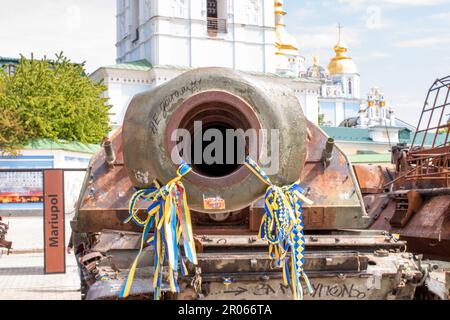 Le canon d'un char russe brûlé avec des rubans jaunes et bleus ukrainiens. Banque D'Images