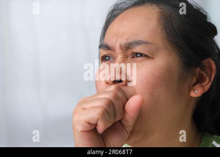 Maladie jeune femme toussant à la maison. Une femme malade toussant les mains. Banque D'Images