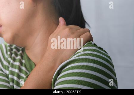 Moody jeune femme tenant son cou. Femme fatiguée massant le cou raide, les muscles fatigués, épuisés du travail. Douleur au niveau du bras supérieur. Santé et médecine Banque D'Images