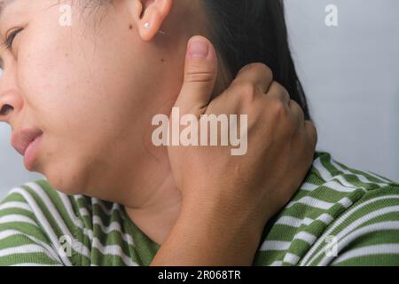 Moody jeune femme tenant son cou. Femme fatiguée massant le cou raide, les muscles fatigués, épuisés du travail. Douleur au niveau du bras supérieur. Santé et médecine Banque D'Images