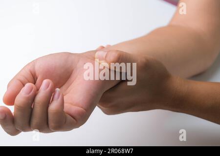 Femme souffrant de douleurs au poignet, d'engourdissement ou de syndrome du canal carpien, d'arthrite, de maladie neurologique. Gros plan de la main de la femme tenant une articulation douloureuse. Banque D'Images