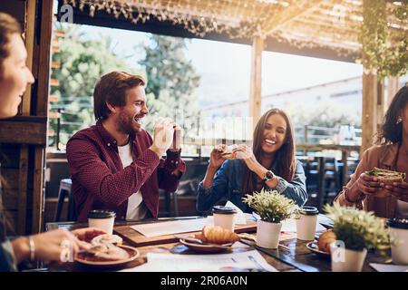 Que le meilleur sandwich eater gagne. des amis qui s'amusent pendant leur déjeuner. Banque D'Images