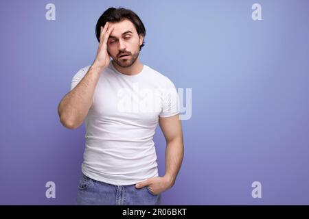 bouleverser un homme brutal de brunette dans un t-shirt blanc et un jean Banque D'Images