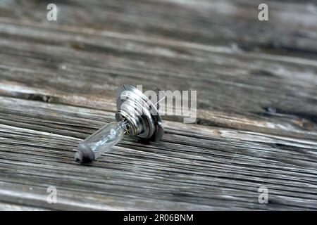 Ampoule de phare de voiture installée dans la lampe de véhicule avant de voitures isolées sur fond de bois, foyer sélectif de l'appareil d'éclairage de voiture de l'automobile Banque D'Images