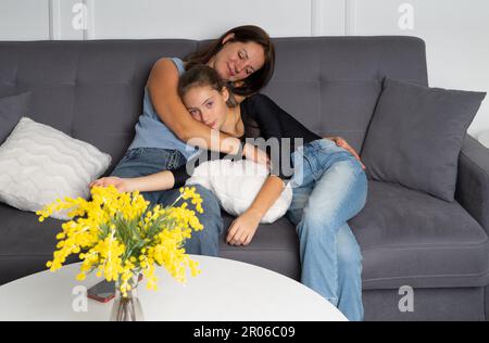 La jeune mère et la jeune fille de l'adolescence essayant des chaussures et choisissant des vêtements ensemble Banque D'Images