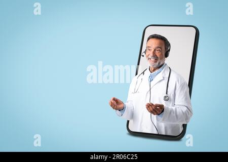 Médecin européen senior positif, manteau blanc, stéthoscope, casque sur grand écran Banque D'Images