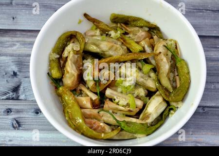 Aubergine rôtie marinée et poivrons verts farcis à l'ail, piment rouge, vinaigre, citron, coriandre, persil, tomates et épices hachées, Banque D'Images