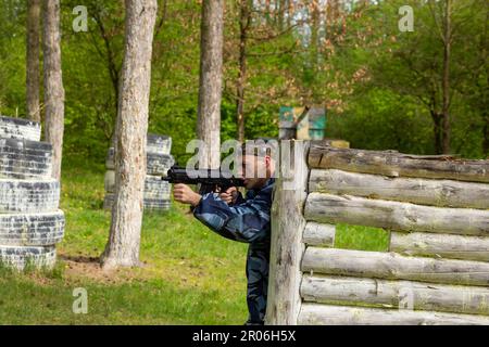 Un jeune homme a pleurée en camouflage jouant au laser dans un terrain de jeu spécial en forêt. Laser Tag est un jeu tactique militaire de commandement utilisant des armes laser sûres Banque D'Images