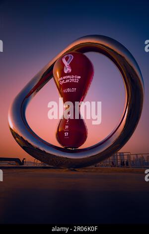 Une grande sculpture rouge du compte à rebours pour la coupe du monde de la Fifa Qatar 2022 au coucher du soleil Banque D'Images