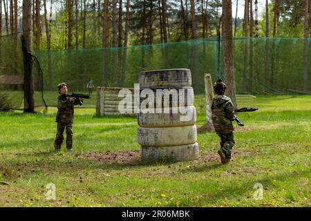 Deux garçons ont pleurés en camouflage jouant au laser tag dans un terrain de jeu spécial en forêt. Laser Tag est un jeu tactique militaire de commandement utilisant des armes laser sûres a Banque D'Images