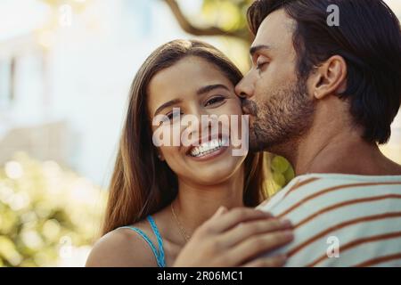 Je lui donne la tête sur les talons. Portrait d'un jeune couple affectueux partageant un baiser à l'extérieur. Banque D'Images