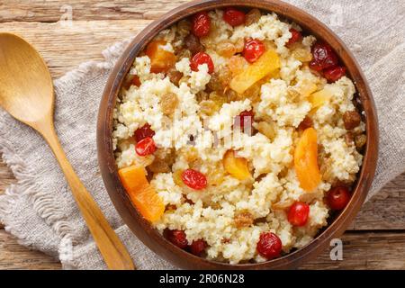 Porridge de millet fait maison avec des abricots séchés, des raisins secs et des cerises dans un bol sur la table. Vue horizontale du dessus Banque D'Images