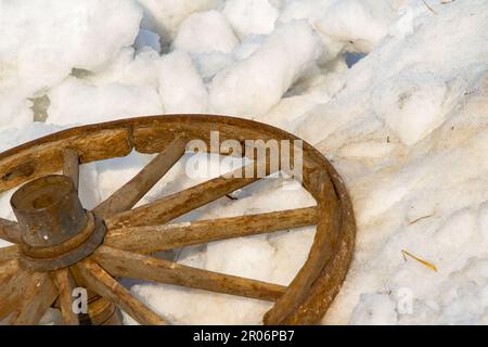 Ancienne roue de chariot. Détruire la roue en bois d'un chariot tiré par des chevaux est jeté sur la neige. Banque D'Images