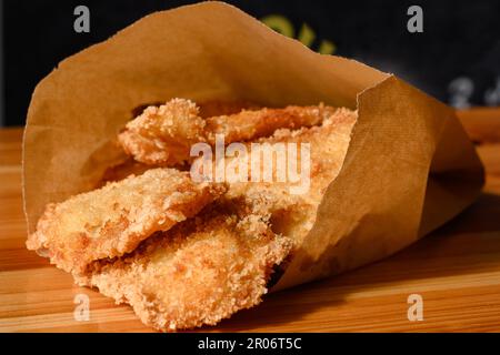 Nuggets de poulet dans un sac en papier sur la table, nuggets de poulet frits cuits. Banque D'Images