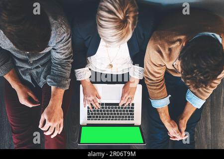 Le succès vient quand vous vous asseyez et travaillez pour lui. Prise de vue en grand angle d'hommes d'affaires à l'aide d'un ordinateur portable doté d'un écran chromé. Banque D'Images