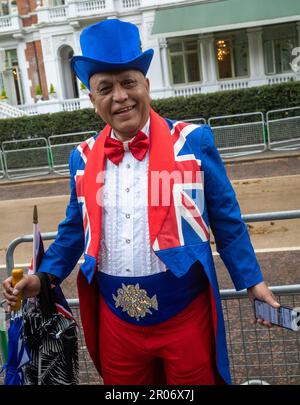 Un homme noir d'âge moyen vêtu d'un chapeau haut et d'une queue hauts en couleur, orné du drapeau syndical, se porte avec enthousiasme le jour du roi Charles III Banque D'Images