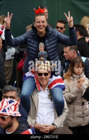 Les amateurs de wishers attendent sur le Mall pour que les membres de la famille royale apparaissent sur le balcon de Buckingham Palace pour admirer le survol de la Royal Air Force après le couronnement du roi Charles III et de la reine Camilla à Londres. Date de la photo: Samedi 6 mai 2023. Banque D'Images