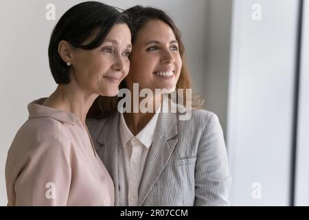 Les femmes d'âge moyen et les jeunes rêvent de jour en regardant la fenêtre Banque D'Images