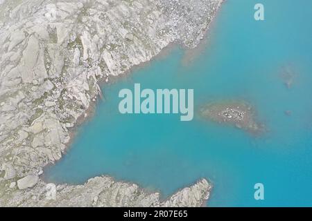 DefAbstract fragments aériens du Lago Vedretta, Val Nambrone – eaux turquoises glaciaires et texturesault de roches alpines Banque D'Images