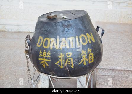 Boîte de dons dans le temple bouddhiste de Hat Yai. Banque D'Images