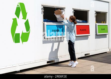 Station de collecte des déchets séparée dans la rue et femme qui jette le papier dans la poubelle. Banque D'Images