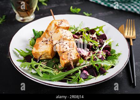 Brochettes de tofu cuites dans une sauce et salade de betteraves, arugula avec sauce au yaourt végétal. Concept alimentaire végétalien sain. Une alimentation saine. Banque D'Images
