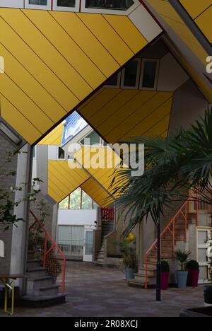 Rotterdam, NL, cour intérieure des maisons cubiques de Piet Blom, ou Kubuswoningen, avec des plantes, des mains courantes rouges et une porte. Banque D'Images