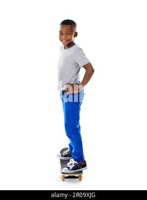 Pourquoi marcher quand vous pouvez skate. Photo en studio d'un petit garçon mignon posant avec son skateboard sur un fond blanc. Banque D'Images