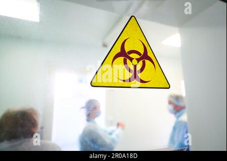 Panneau d'avertissement de danger biologique sur la porte transparente du laboratoire Banque D'Images