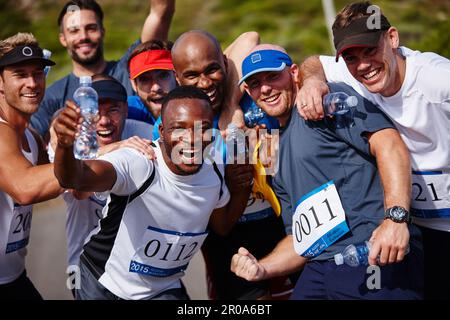 A été ravivé pour cette course. Portrait d'un groupe de jeunes hommes enthousiastes debout ensemble après avoir couru un marathon. Banque D'Images