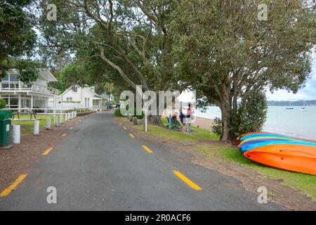 Russel Nouvelle-Zélande - 2 février 2011; kayaks colorés sur la rive sous les arbres pohutukawa entre la rue et le bord de l'eau. Banque D'Images