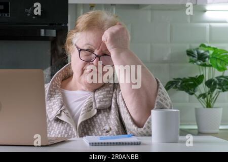 La vieille femme est contrariée de ne pas pouvoir faire quelque chose avec son ordinateur portable Banque D'Images
