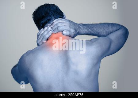 Le vieillissement est une douleur dans le cou. Vue arrière en studio photo d'un homme mûr frottant la blessure mise en évidence sur son corps. Banque D'Images