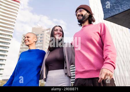 trois amis rient et embrasent pendant une promenade Banque D'Images