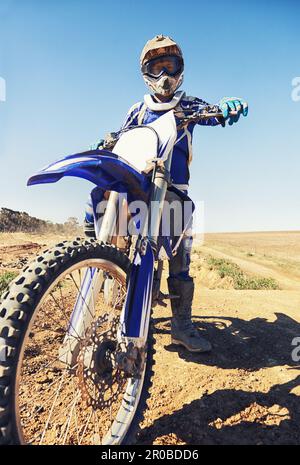 Prêt à tout affronter. Portrait d'un motocross assis sur son vélo en équipement de protection complet. Banque D'Images