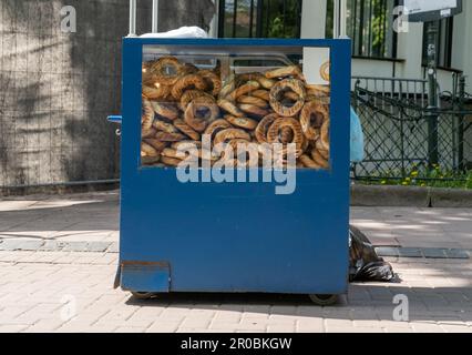 Street vendor chariot de vente Krakowskie Obwarzanki à Cracovie, Pologne. Stand de Cracovie avec Obwarzanek Krakowski, en-cas polonais traditionnel de Cracovie. Banque D'Images