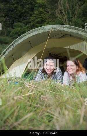 Portrait d'un jeune couple se détendant dans une tente de camp, Bavière, Allemagne Banque D'Images