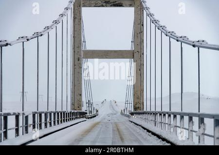 Point de vue du conducteur sur le pont suspendu au-dessus de la rivière Jökulsá qui relie le glacier de la lagune de Jokulsarlon à la mer pendant la tempête de neige Banque D'Images