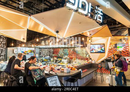 Yo ! Restaurant sushi dans le salon de départ du terminal 3 de l'aéroport de Heathrow. Deux personnes attendent d'être assis, d'autres mangeant au comptoir. Banque D'Images