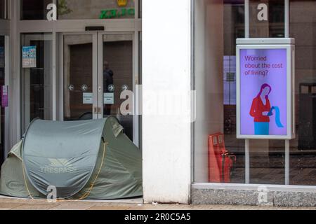 « Inquiet du coût de la vie » signalétique numérique de la banque à Preston, dans le Lancashire. 8 mai 2023 météo au Royaume-Uni. Le sommeil agitée, ayant érigé une tente dans la porte de SANTANDER Bank. Magasins, shopping lors d'un jour férié humide et venteux à Preston. Crédit; MediaWorldImages/AlamyLiveNews Banque D'Images