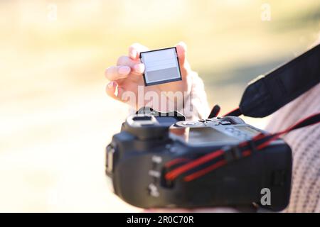 Gros plan d'un photographe qui change de carte sur un appareil photo reflex numérique Banque D'Images